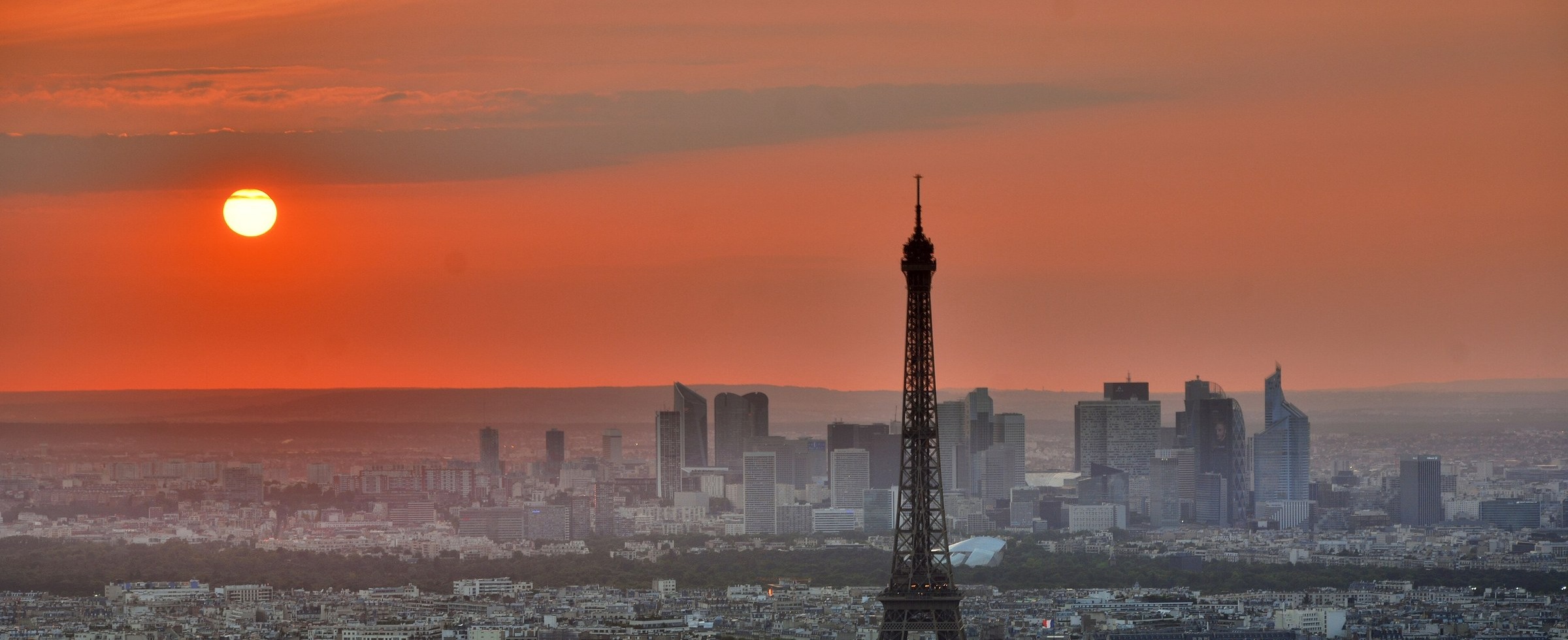 The Eiffel Tower at sunset over the Paris skyline